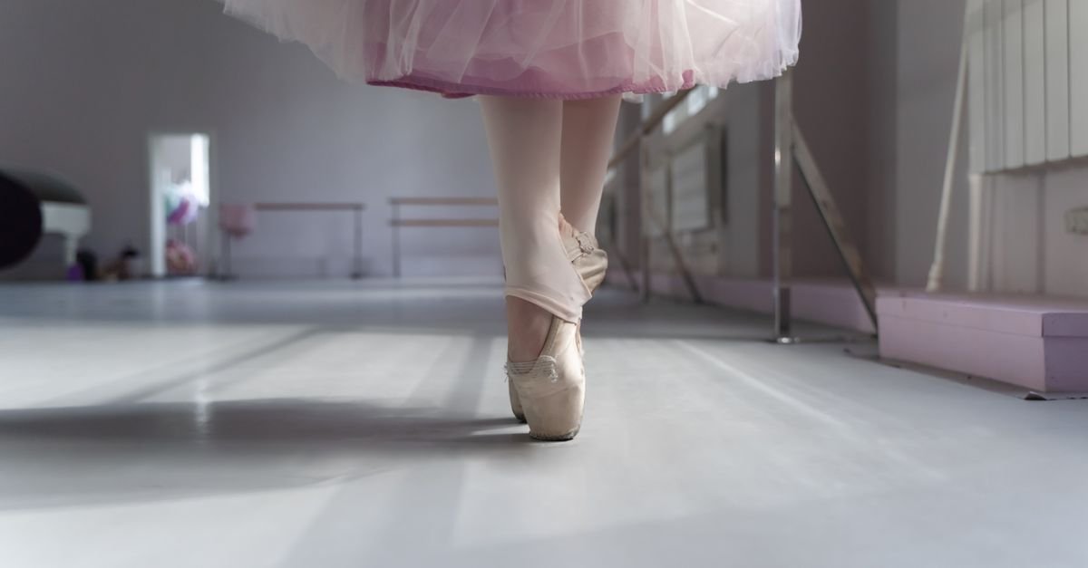 Bailarina em sapatilhas de ponta em sala de ensaio de dança