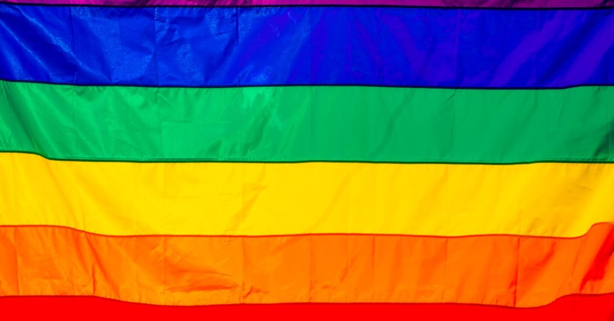 Bandeira do arco-íris estendida, com as faixas coloridas ocupando todo o quadro