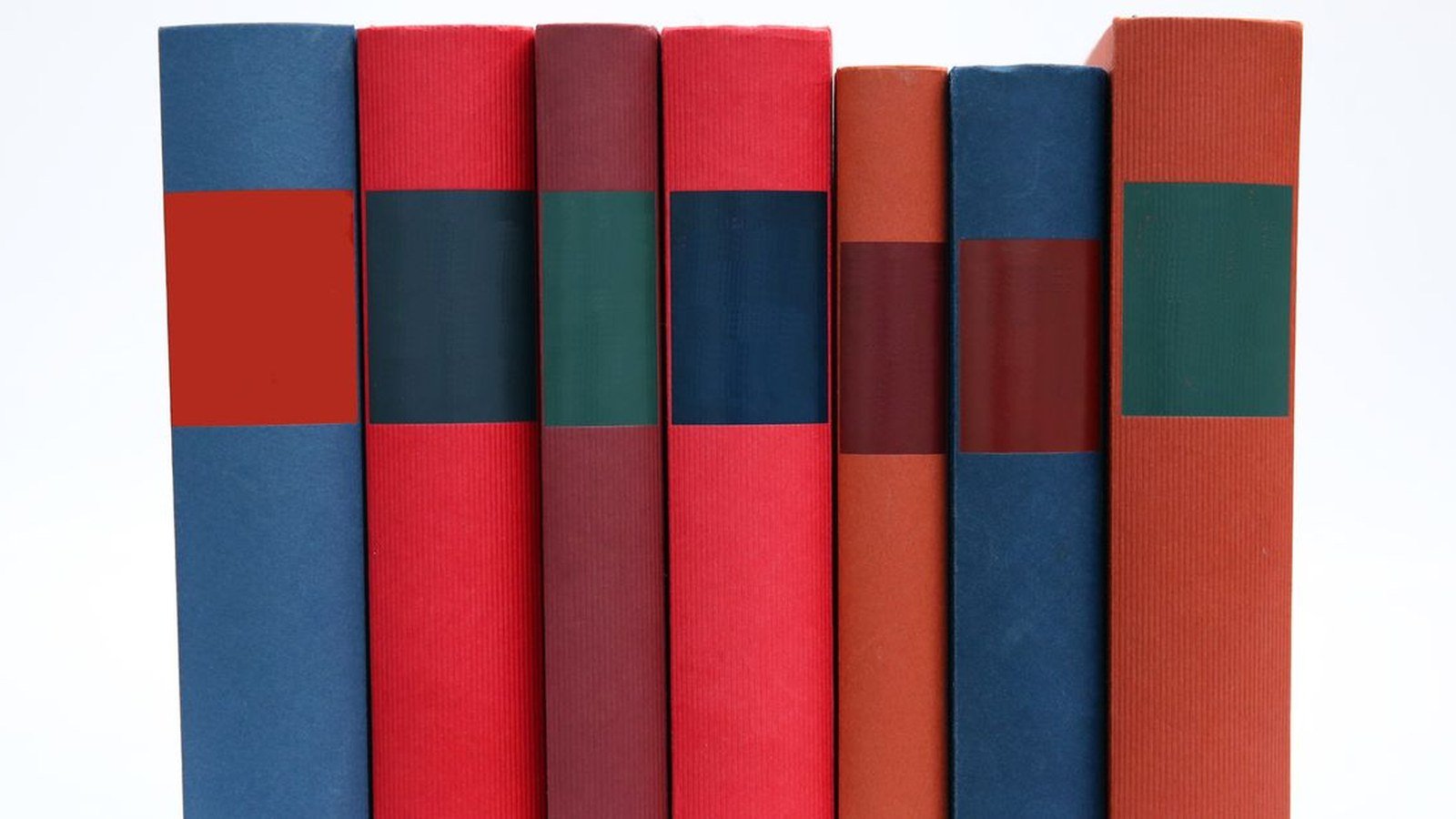 Lombadas de livros coloridos enfileirados sobre fundo branco