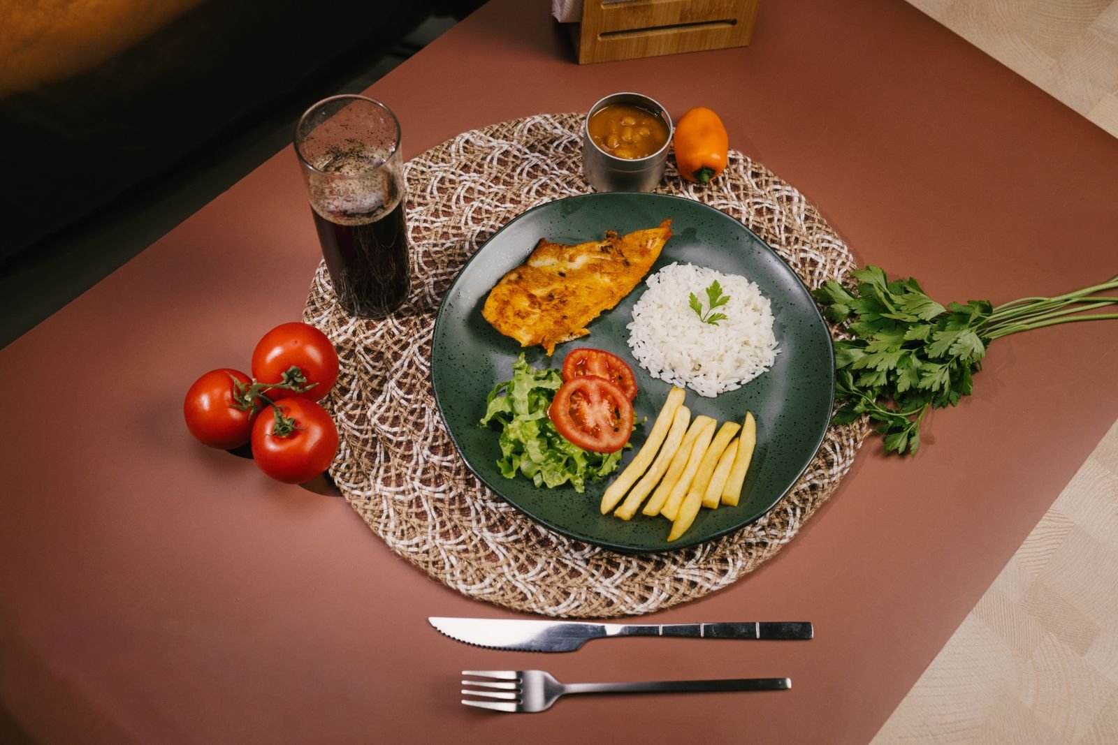 Prato de peixe grelhado com arroz, batata frita e salada em mesa de restaurante (foto ilustrativa de banco de imagens)
