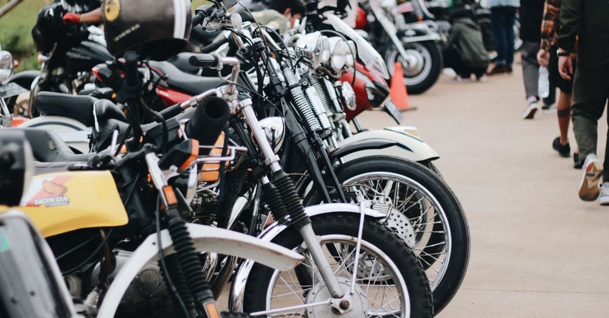Fila de motocicletas estacionadas lado a lado em evento ao ar livre
