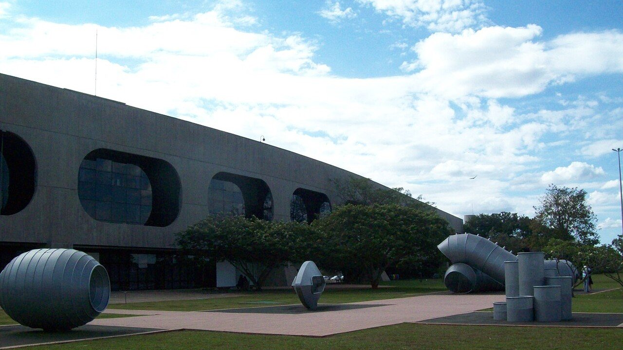 Fachada e jardim do Centro Cultural Banco do Brasil em Brasília, com esculturas no gramado