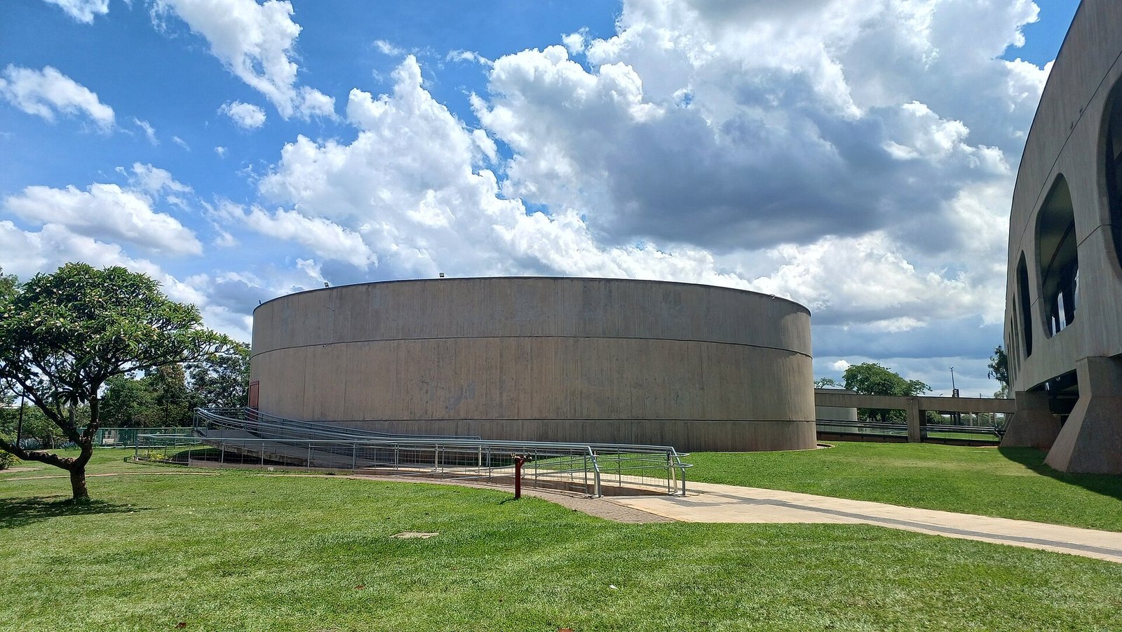 Volume circular de concreto do teatro do CCBB Brasília, com o Edifício Tancredo Neves ao lado