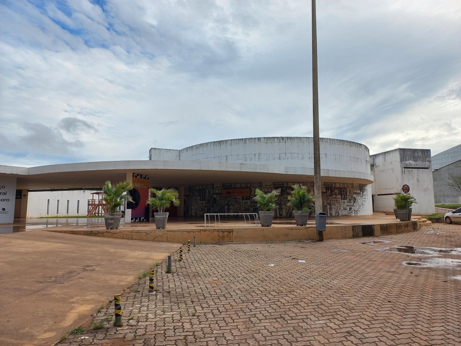 Fachada curva de concreto do Clube do Choro de Brasília, com vasos de palmeira na entrada, em foto de arquivo