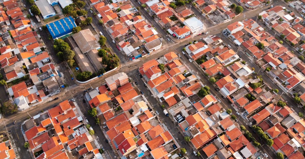 Vista aérea de bairro brasileiro com telhados de cerâmica alinhados em quadras