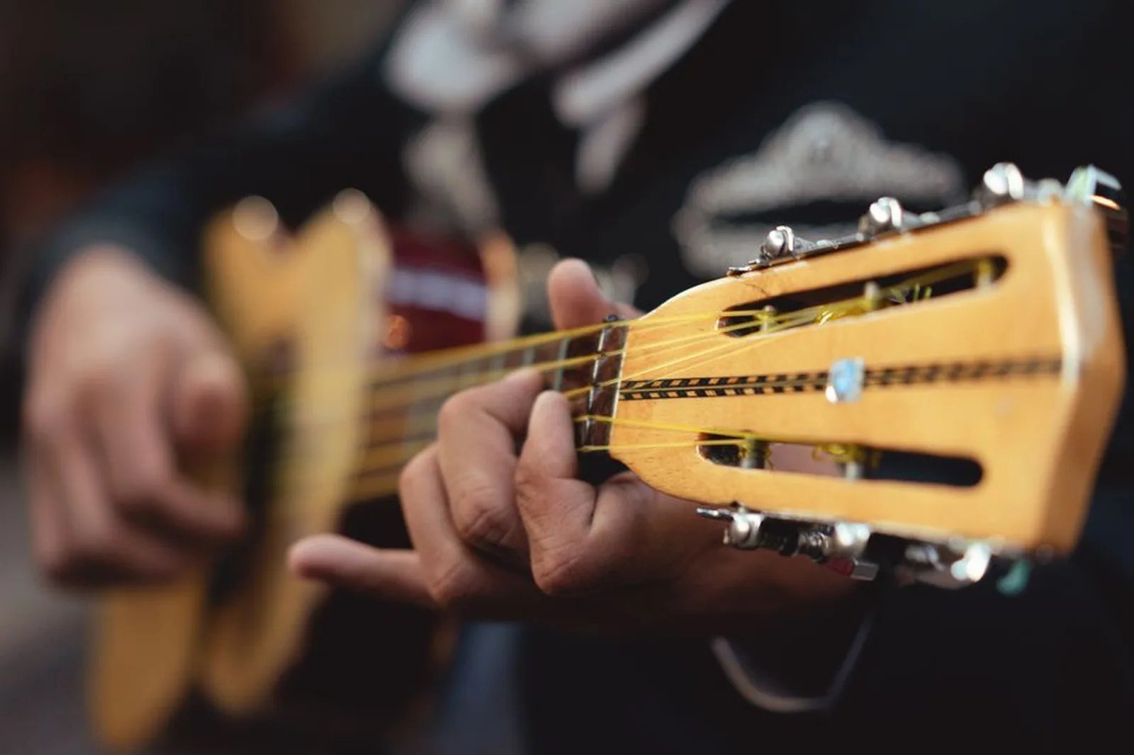 Mãos tocando cavaquinho em close