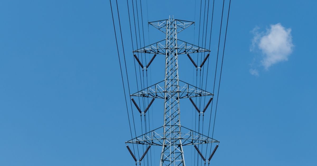 Torre de transmissao de energia eletrica vista de baixo contra ceu azul