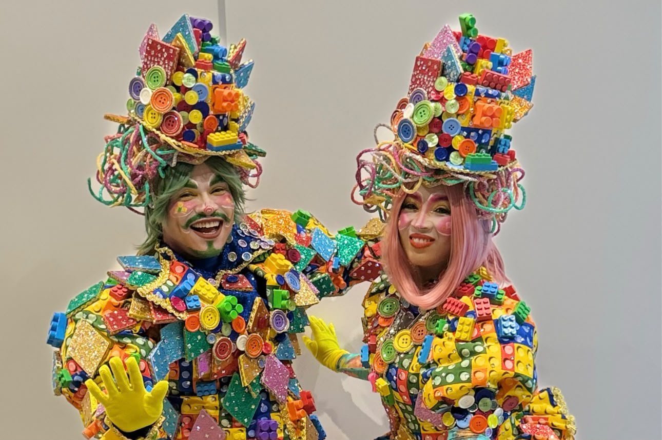 Dois artistas com figurinos feitos de peças de montar coloridas, em foto de divulgação do Pontão