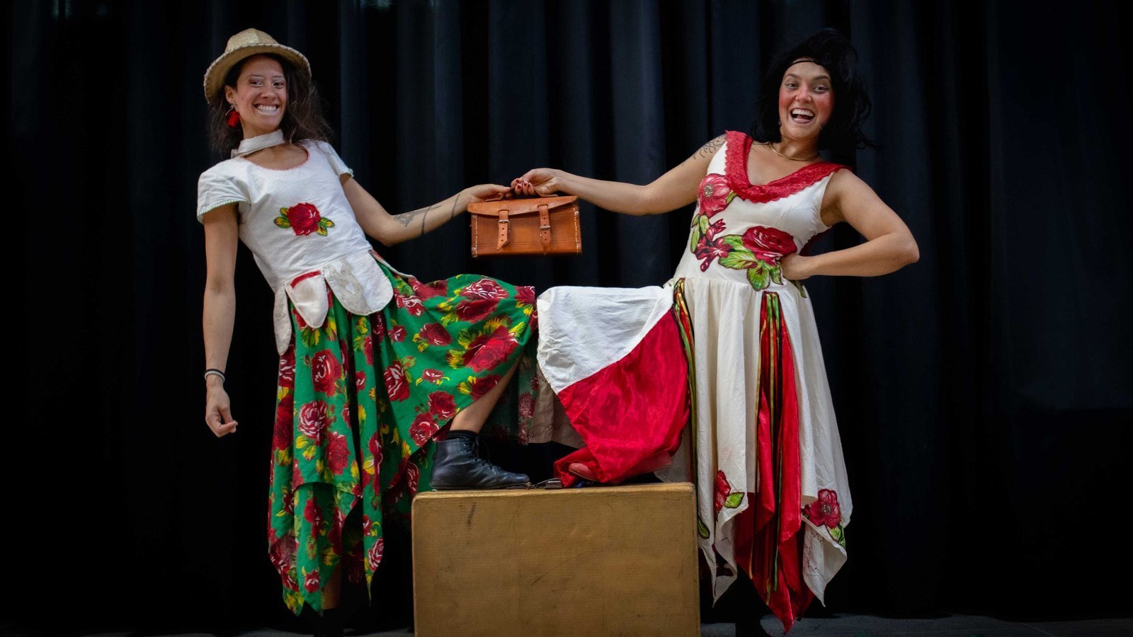 Duas artistas do grupo As Pareias, fantasiadas e coloridas, em apresentação; o grupo se apresenta no Querido Festival