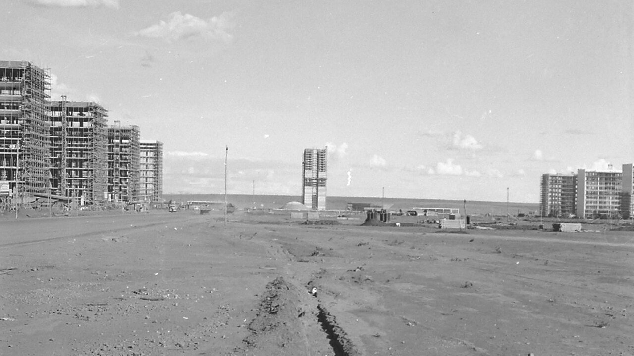 Blocos residenciais em construção e terreno de terra batida na Brasília do fim dos anos 1950