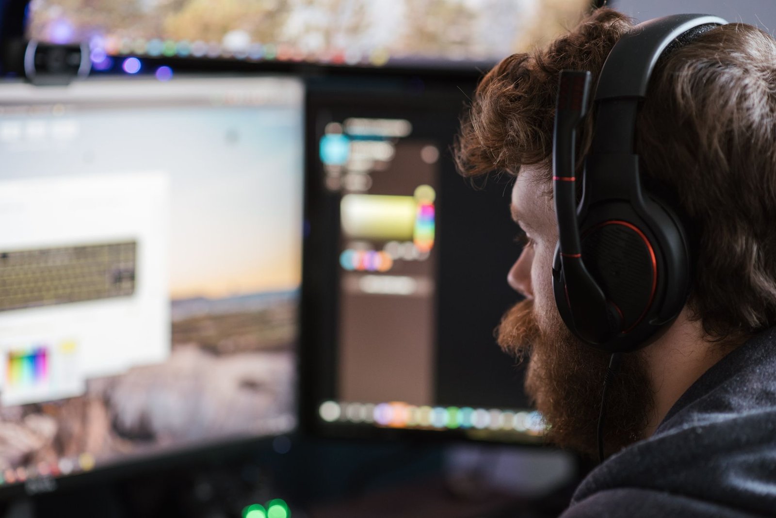 Desenvolvedor de jogos de fone de ouvido diante de dois monitores
