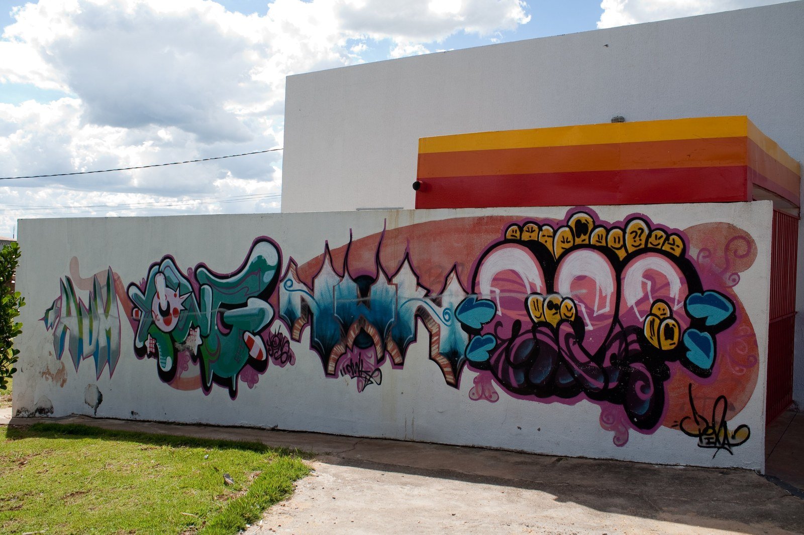 Muro grafitado com letreiro colorido em rua do Distrito Federal