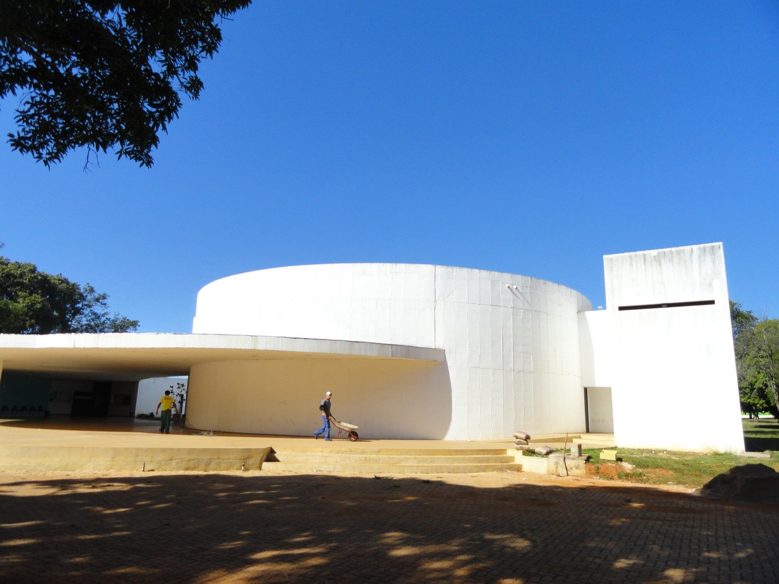 Prédio circular de concreto branco do Clube do Choro de Brasília sob céu azul