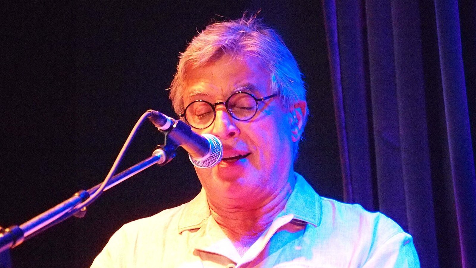 Ivan Lins canta ao microfone durante apresentação