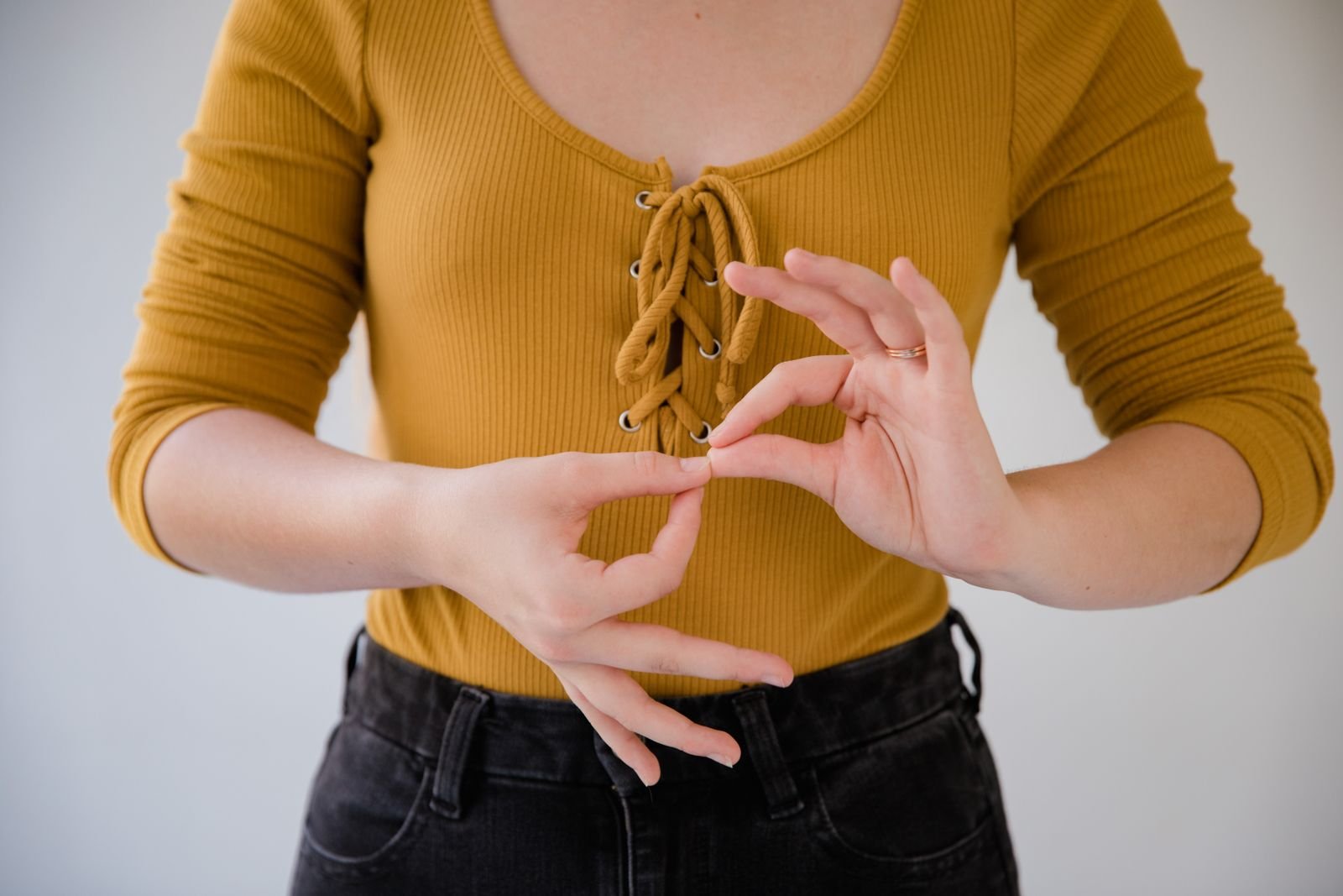 Pessoa fazendo sinal em Libras com as mãos