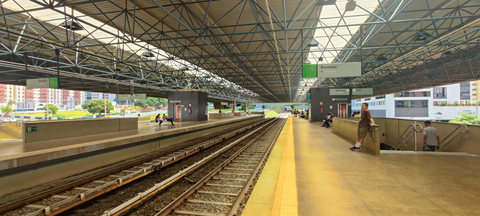Plataforma da estação Águas Claras do Metrô-DF, com prédios residenciais ao fundo