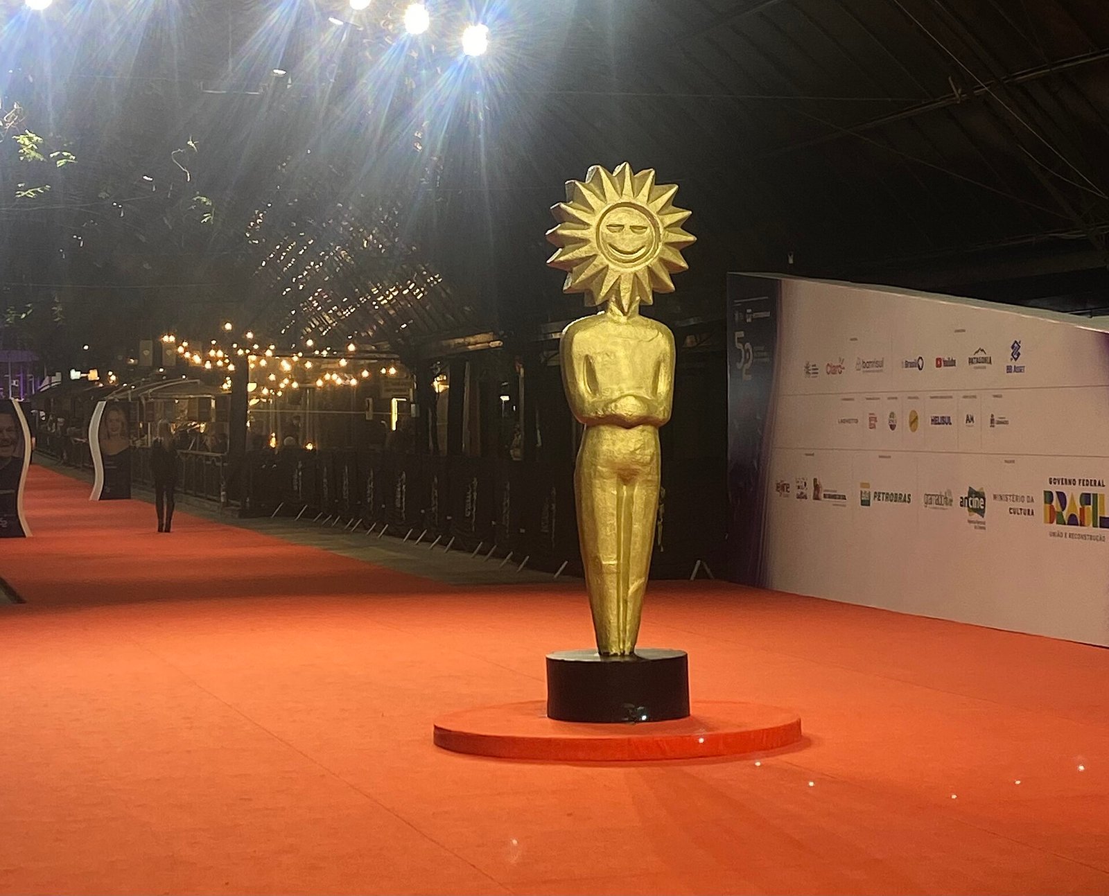 Estátua dourada do Kikito, troféu do Festival de Gramado, sobre o tapete vermelho do evento