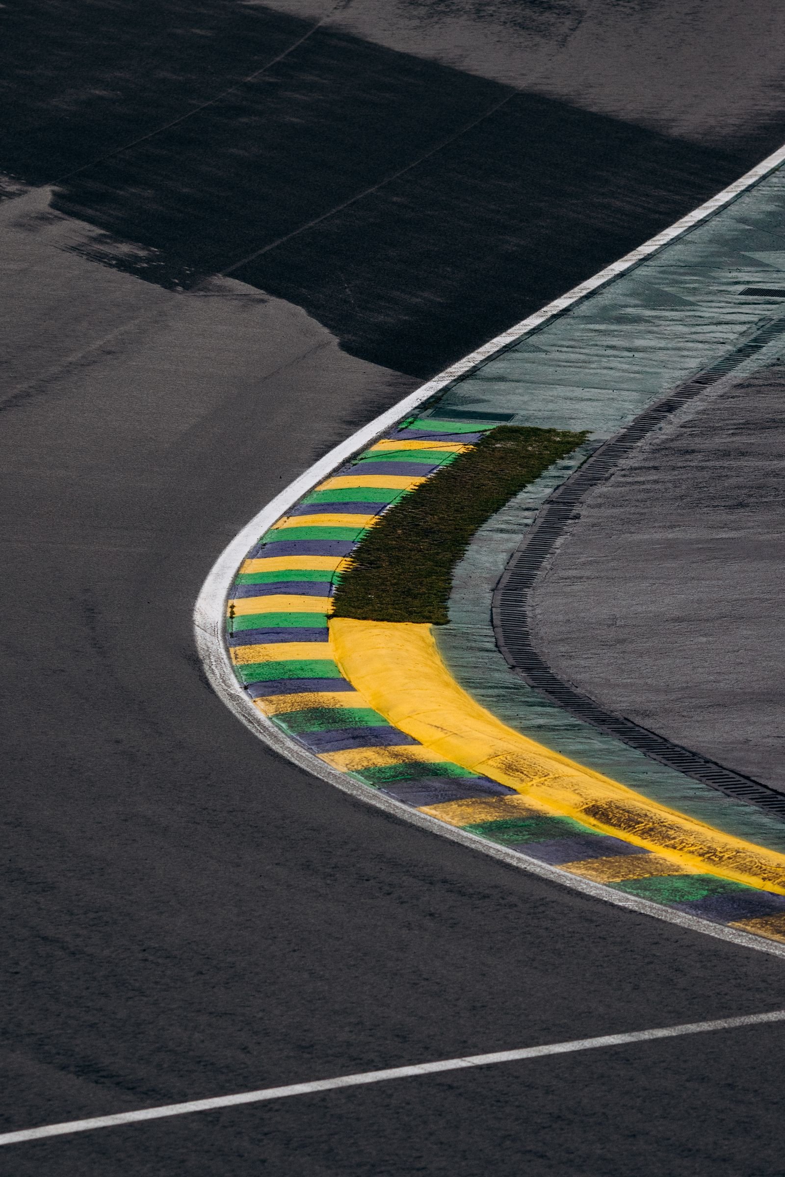Zebra colorida em curva de autódromo, close-up do asfalto e do meio-fio pintado