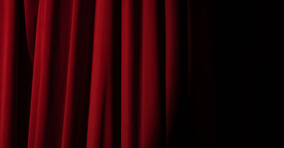 Cortina de veludo vermelho iluminada em palco escuro