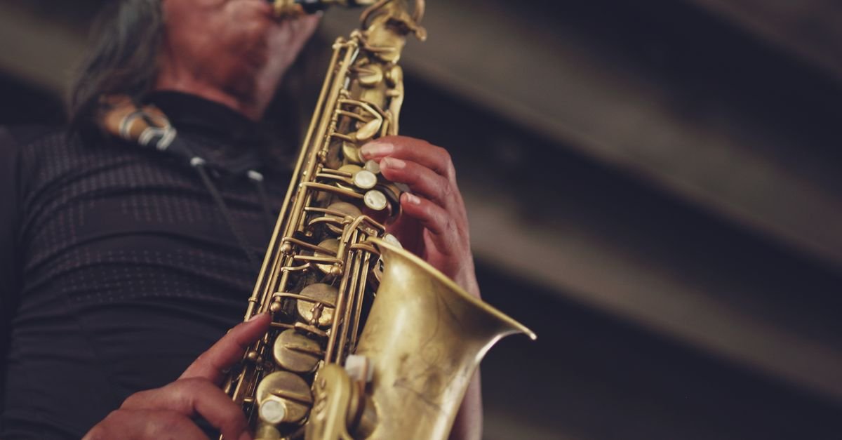 Saxofone dourado em close nas mãos de músico durante apresentação