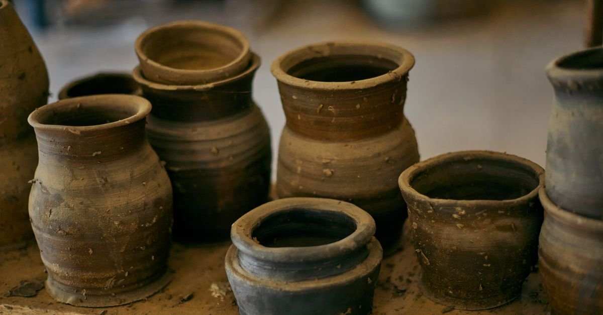 Peças de cerâmica artesanal expostas em prateleira de madeira