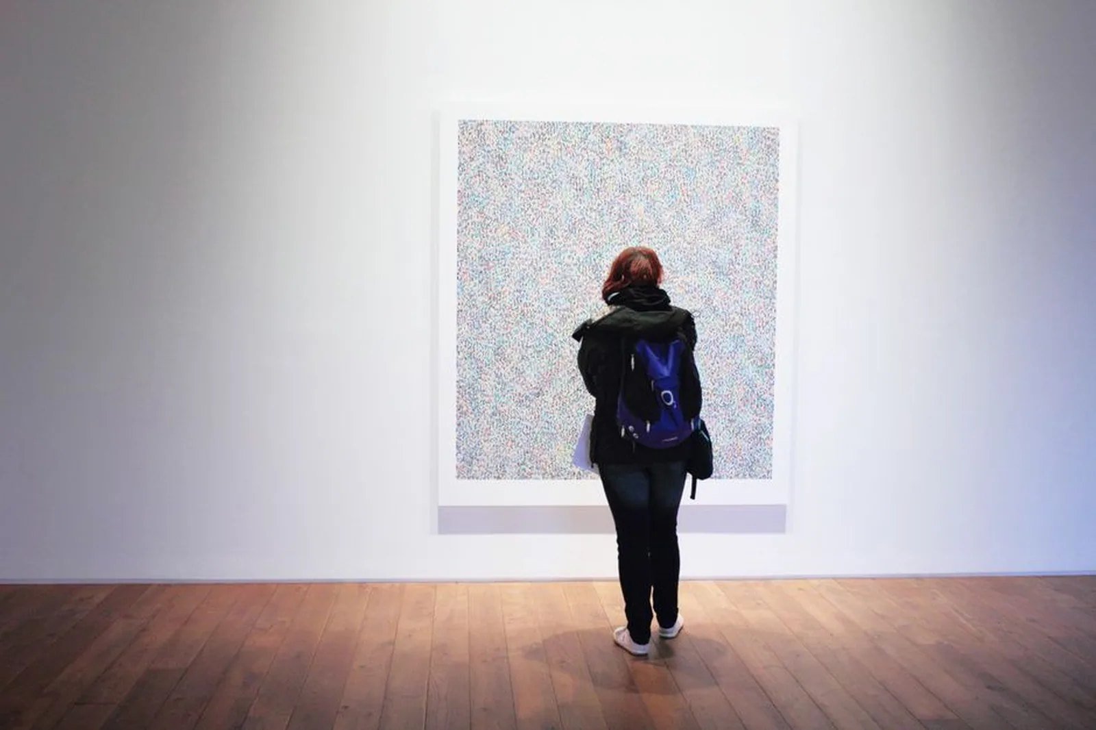 Visitante observando obra em galeria de arte contemporânea