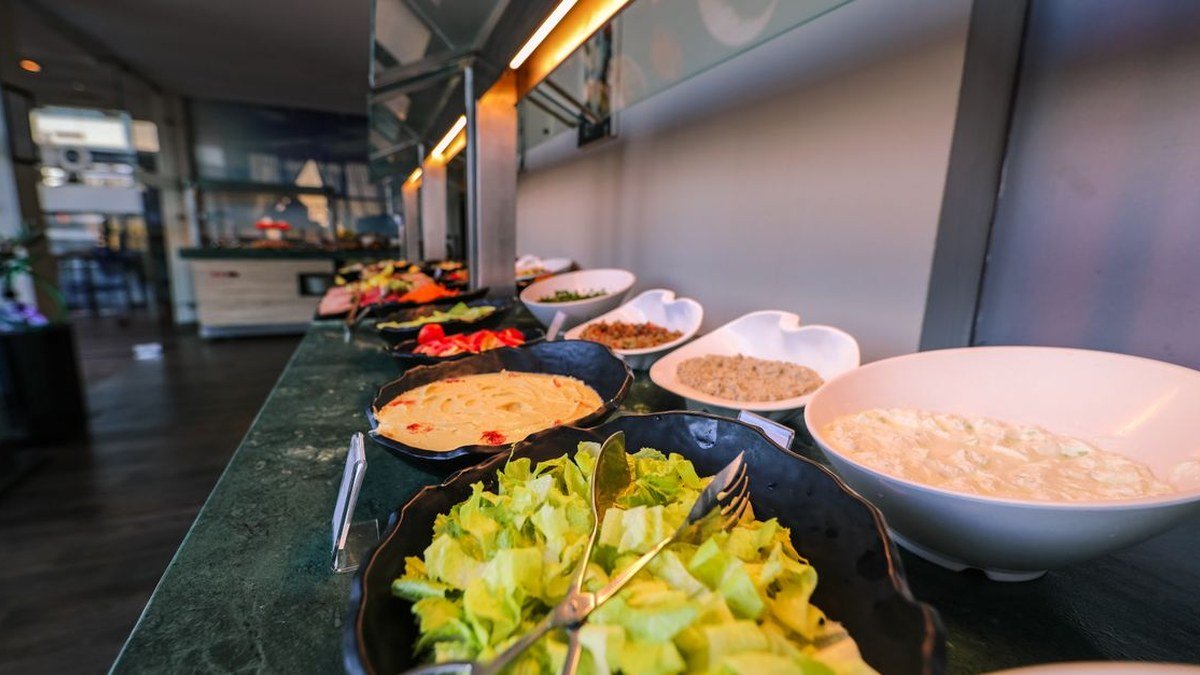 Cubas de saladas e acompanhamentos em balcão de buffet de restaurante