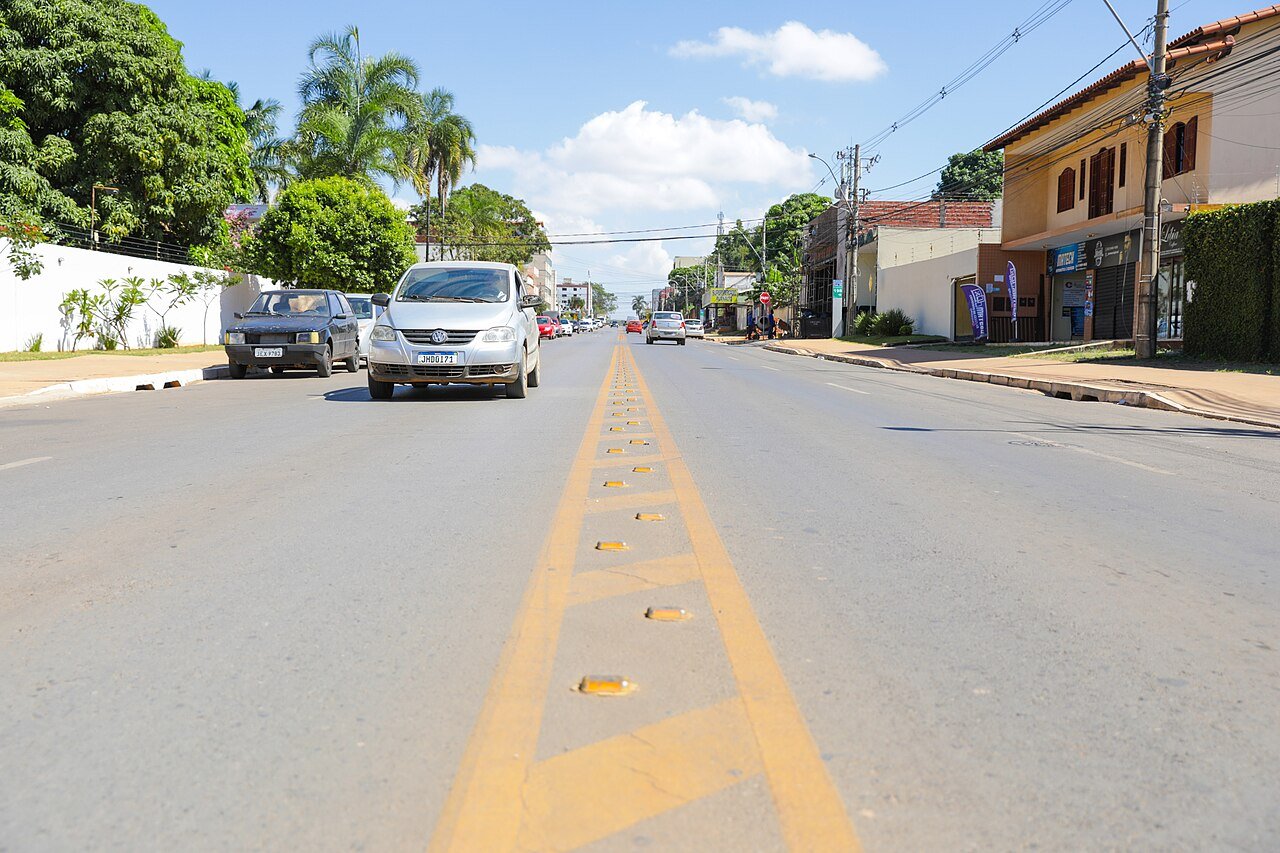 Via comercial de Vicente Pires com carros estacionados na lateral e comercio ao fundo