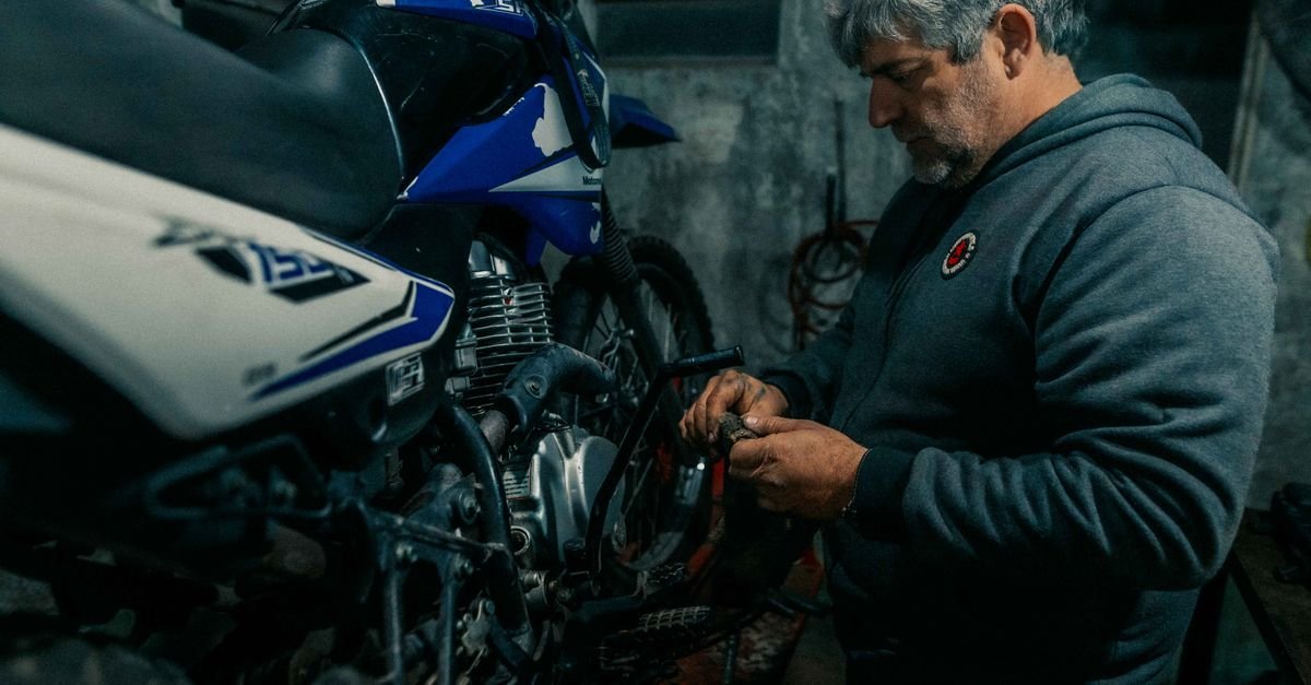Mecanico desmonta motocicleta em garagem com pouca luz