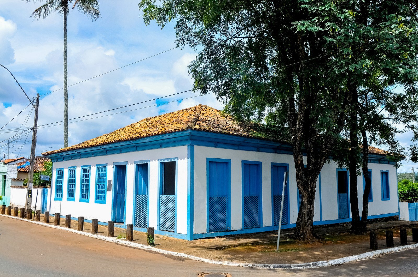 Casario colonial do centro histórico de Planaltina visto da rua, com árvores e calçada