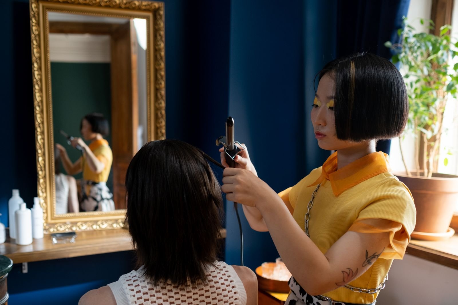 Cabeleireira modelando o cabelo de uma cliente em salão, uma das profissões oferecidas nos cursos