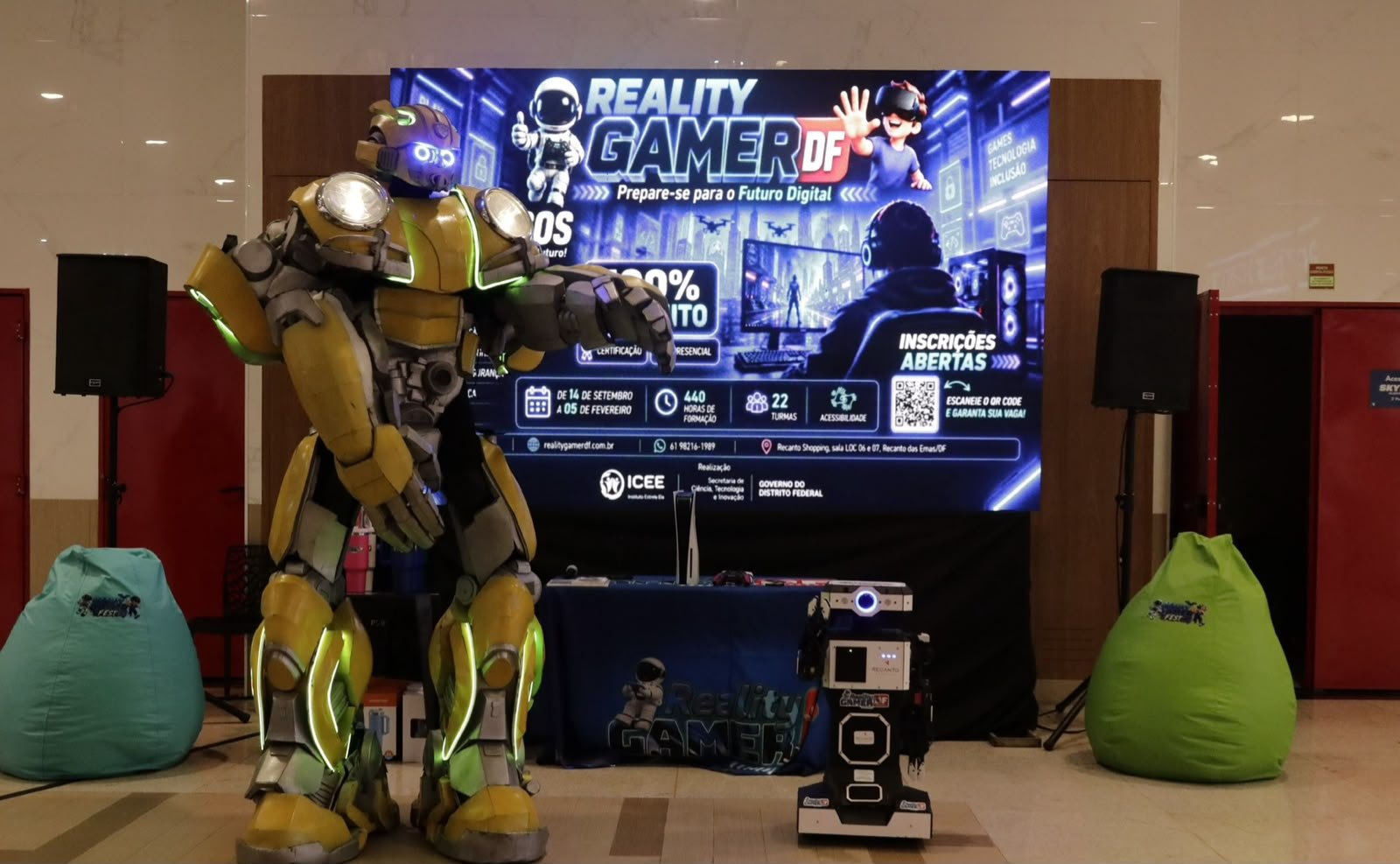 Personagem Bumblebee ao lado do painel do Reality Gamer DF e de um robô, no Recanto Shopping