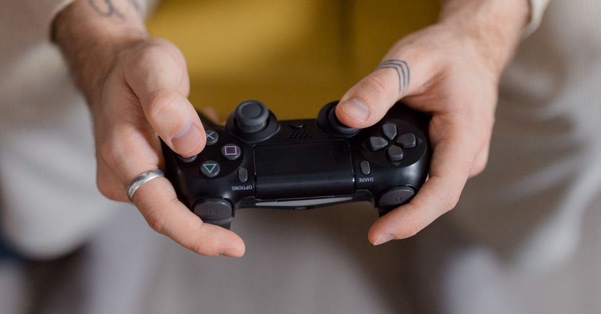 Mãos segurando um controle de videogame preto