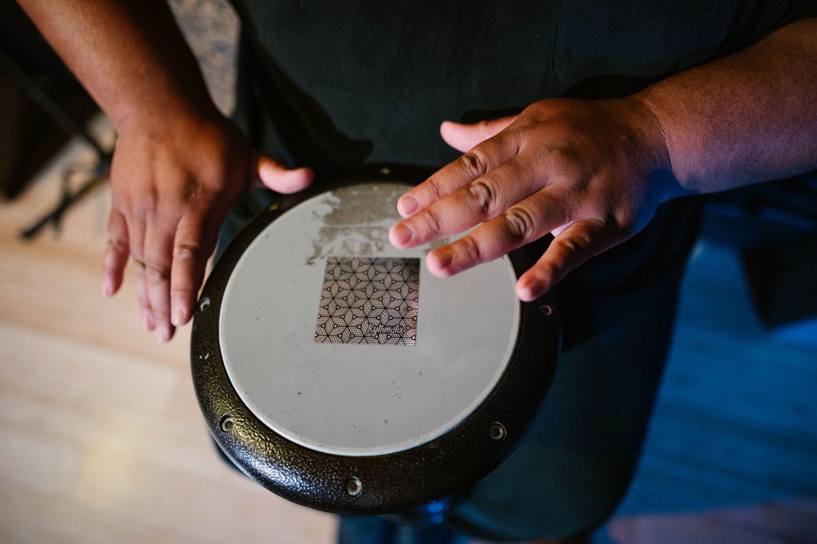 Mãos de um percussionista sobre um tambor de mão durante uma apresentação