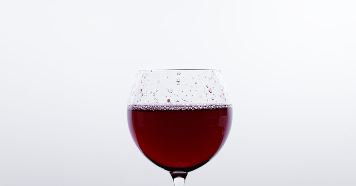 Taça de vinho tinto sobre fundo branco, imagem que ilustra matéria sobre a Sunset Wine Run na Vinícola Brasília
