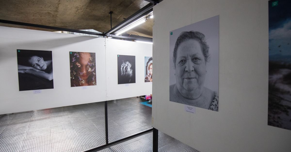 Parede de galeria com retratos fotográficos emoldurados expostos em painéis brancos