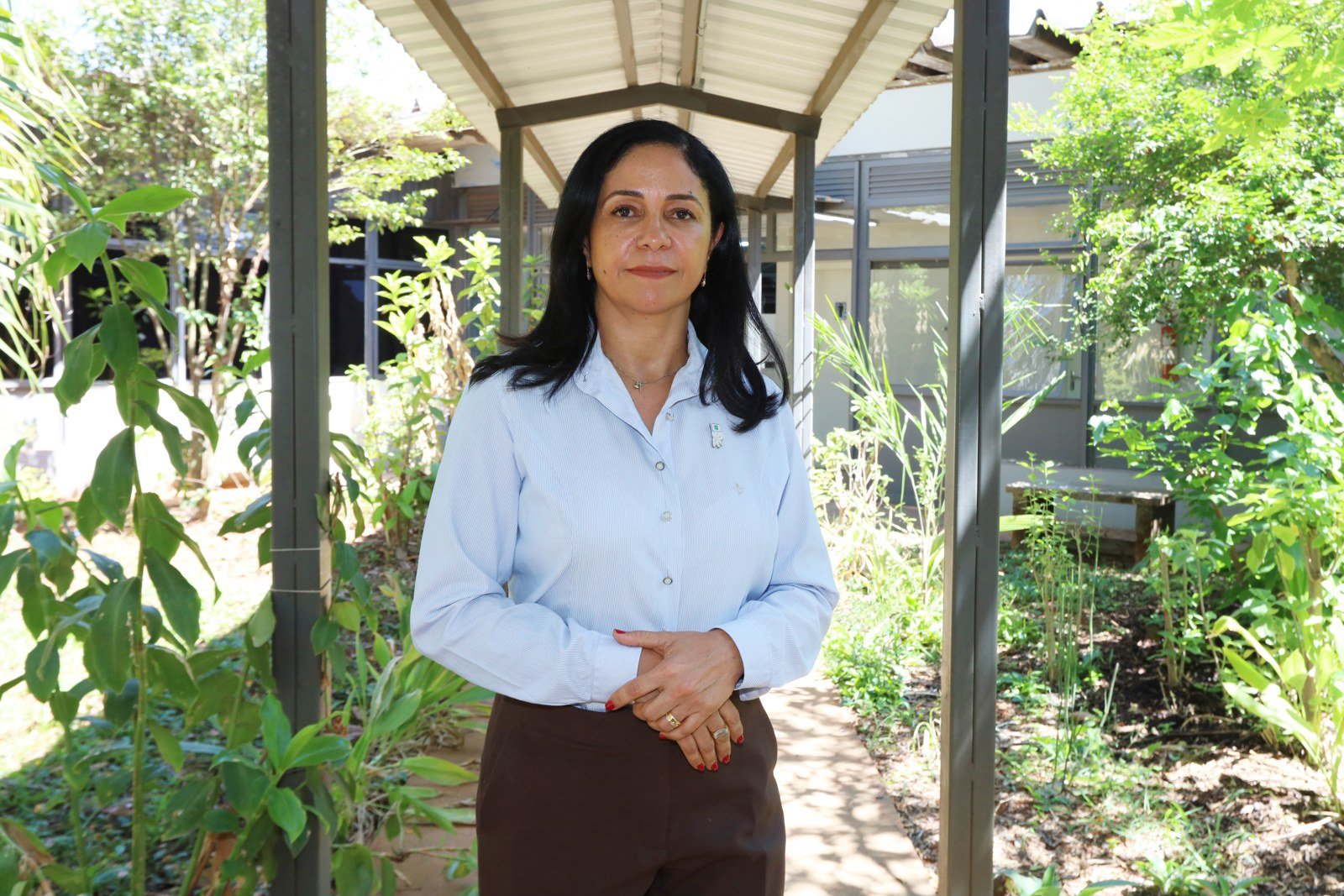 Márcia Olivé, diretora da Vigilância Sanitária do DF, em área externa arborizada